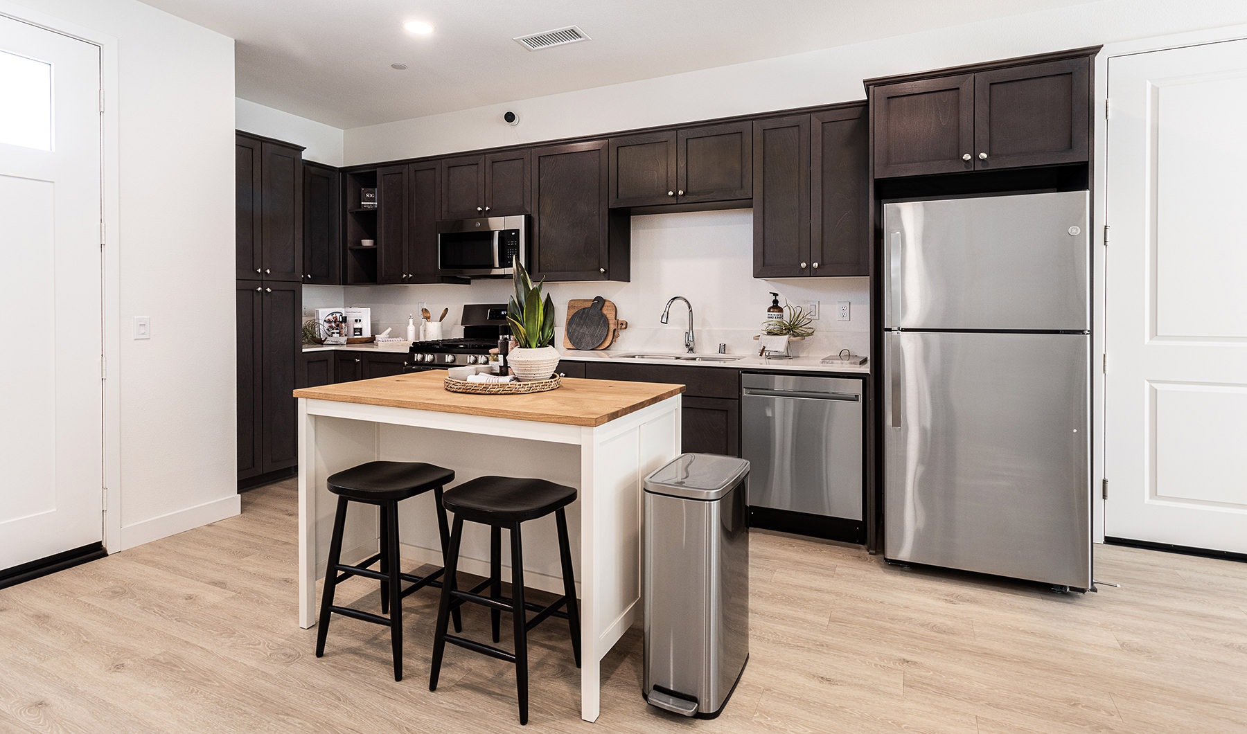 Kitchen Spacious and well lit kitchen with wood floors and stainless steel appliances